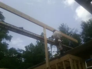 Carpenter setting a ridge beam over a new addition frame — Ice Dam Removal by Roofing Brothers in Grouse Creek