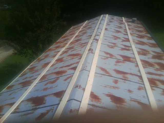 Rusted metal roof panels with new wood purlins before replacement — Storm Damage Roof Repair in Grouse Creek by Roofing Brothers
