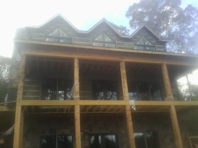 Dormers and porch framing on a large log home under construction — Roof Coating work by our crew in Grouse Creek