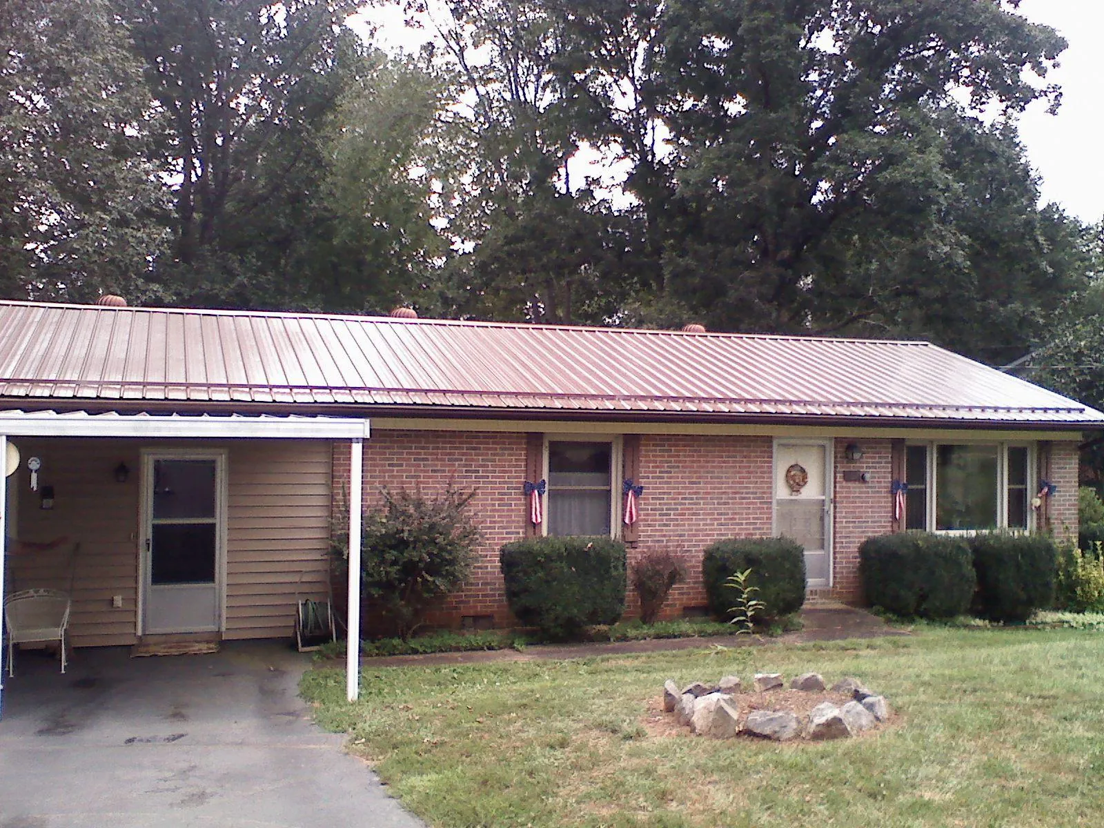 Bronze metal roof and carport on a brick ranch home — Roof Repair work by our crew in Grouse Creek