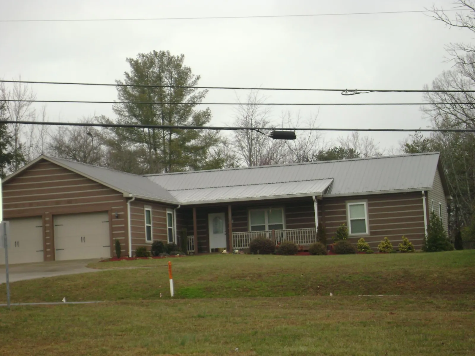 Gray metal roof on a log sided ranch home with a front porch in Grouse Creek